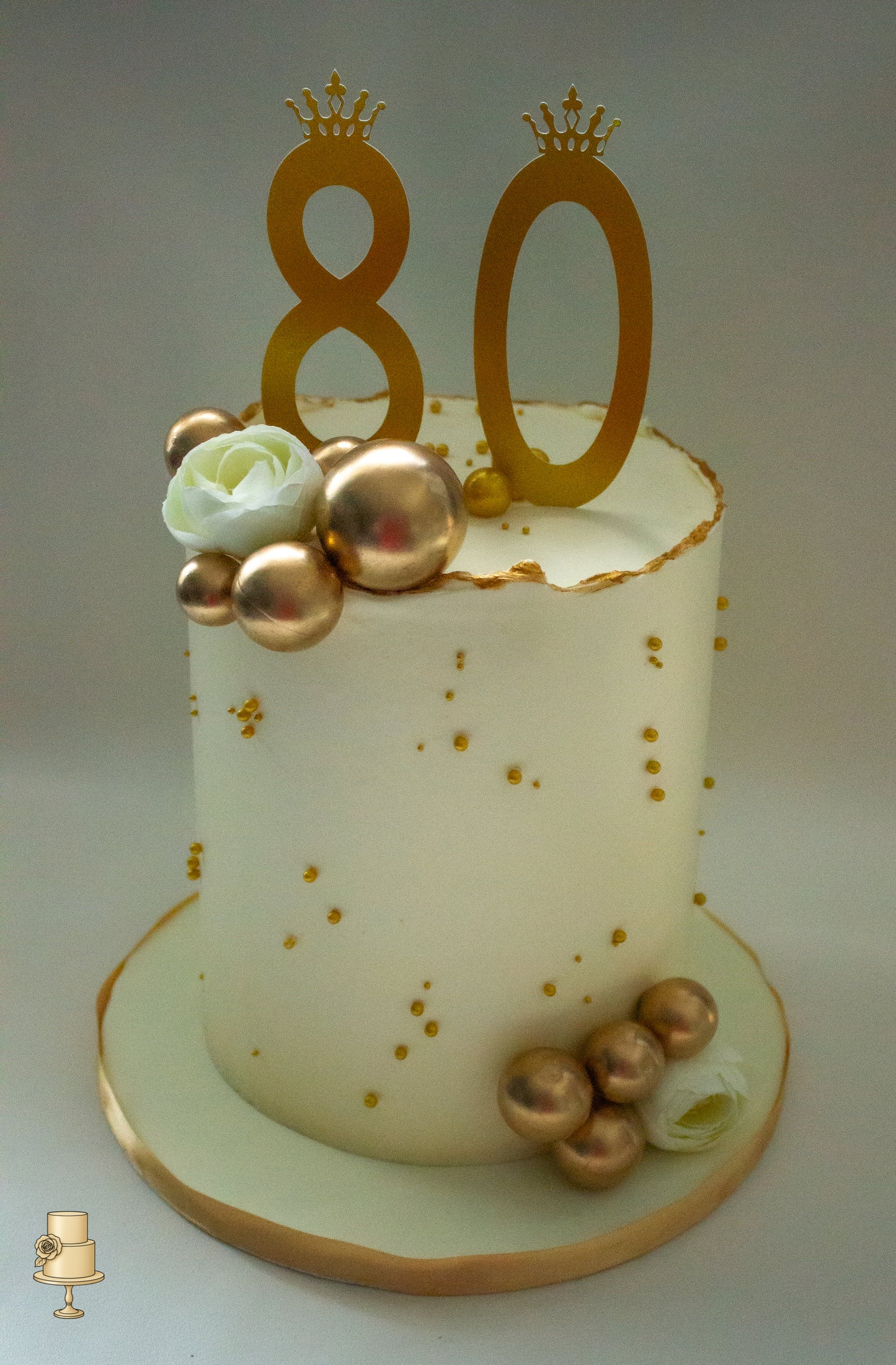 White buttercream cake with gold decorations and number 80
