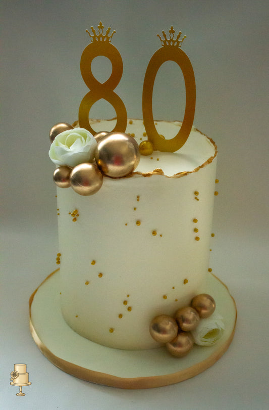 White buttercream cake with gold decorations and number 80 
